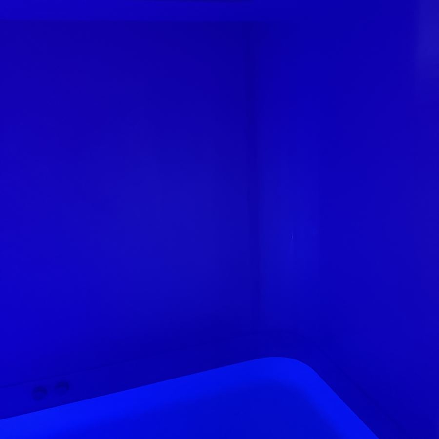 Inside a float tank, lit deep blue
